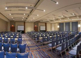 Wide shot of 10 rows of chairs facing projection screens 