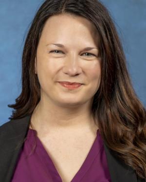 Headshot of Megan VanDam wearing a purple top with a black blazer.