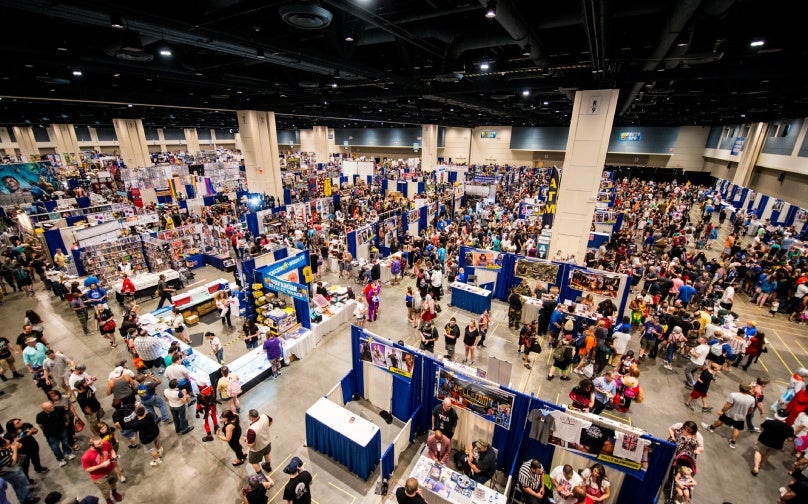 Trade show in an exhibit hall with vendor booths and attendees.