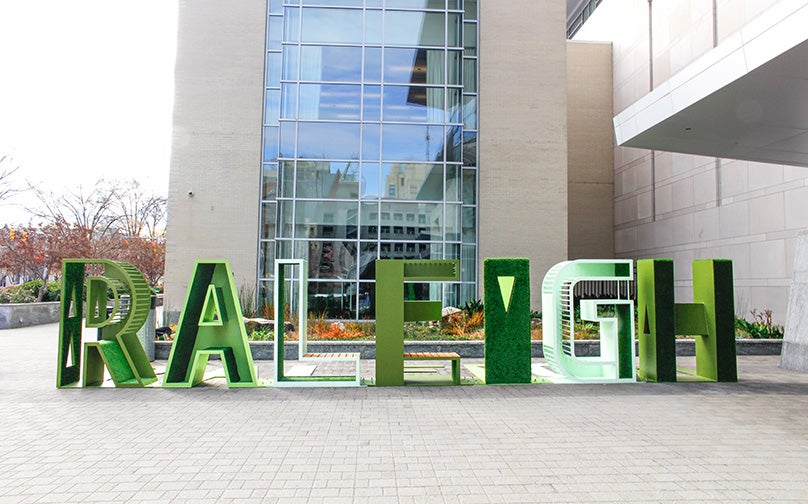 Green &quot;RALEIGH&quot; sign next to the Raleigh Convention Center.