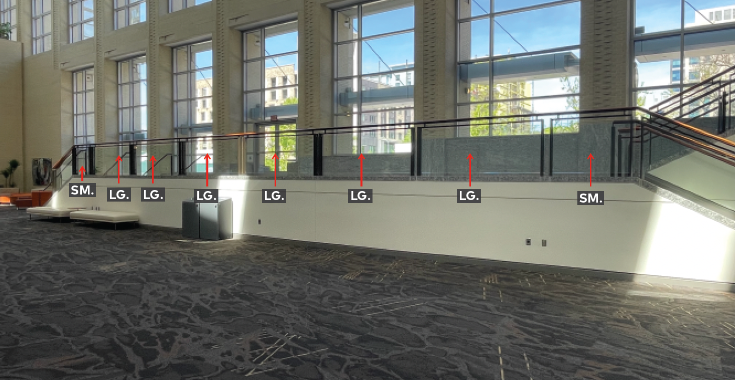 Lower mezzanine landing with railing and glass panels.