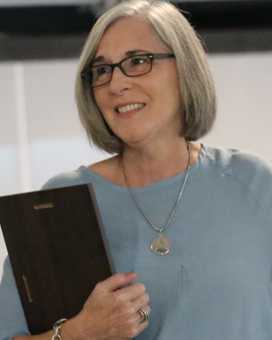 Headshot of Sherry Fadool looking to the side and smiling while holding a clipboard.