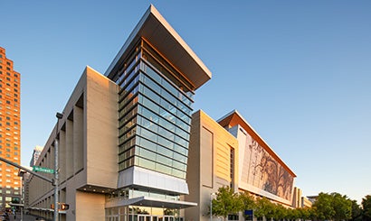 Exterior of the Raleigh Convention Center showing large windows and shimmer wall in daytime.