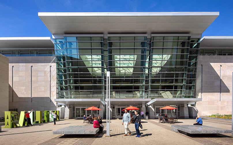 View of the entrance to Raleigh Convention Center with people gathered and walking around.