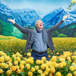 Photo of Rick Steves in a field of yellow flowers imitating Maria in The Sound of Music
