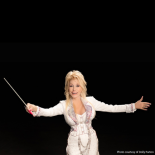 Photo of Dolly Parton in a white outfit on a black background