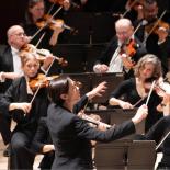 Photo of conductor with violin section