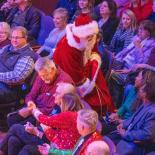 Photo of Santa walking through seated audience members