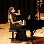 Photo of woman sitting at grand piano