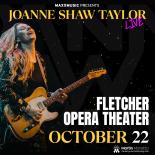 Joanne Shaw Taylor playing guitar against black background