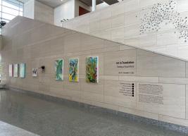 South-facing hallway displaying works by Johnson, Markowitz, and Lapetina, as well as the exhibit description. Swarm sits in the background.