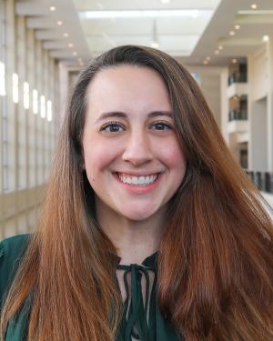 Brunette woman stands in the Raleigh Convention Center and smiles for the camera.